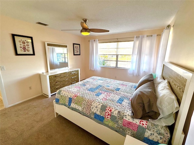 carpeted bedroom with ceiling fan and a textured ceiling