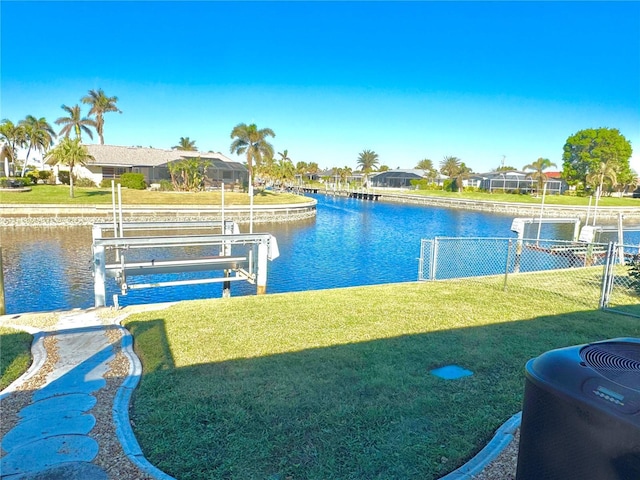 dock area with a water view and a lawn