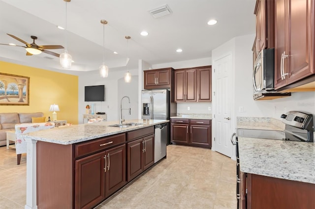 kitchen with sink, ceiling fan, an island with sink, decorative light fixtures, and stainless steel appliances