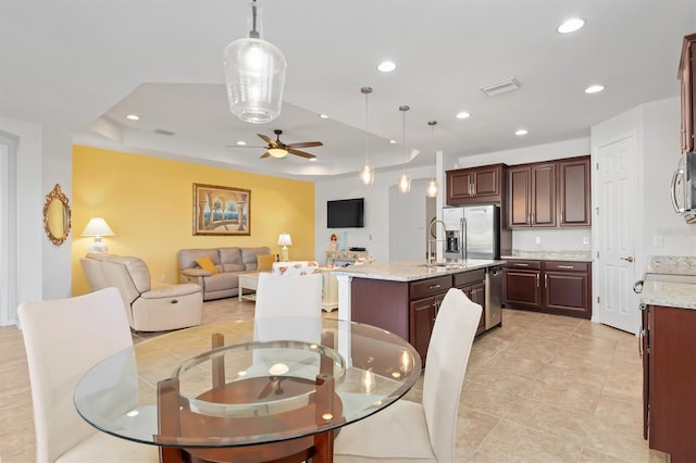 tiled dining room featuring ceiling fan and a tray ceiling