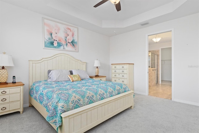 bedroom featuring light carpet, a raised ceiling, and ceiling fan