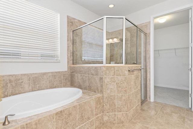 full bathroom with a spacious closet, a shower stall, tile patterned floors, and a garden tub