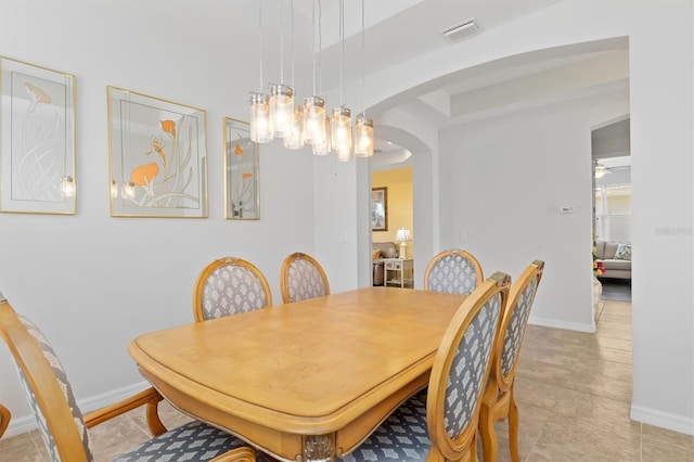 dining area with arched walkways, visible vents, and baseboards