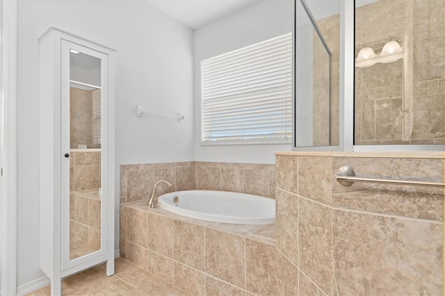 full bathroom with tile patterned flooring, a bath, and a tile shower