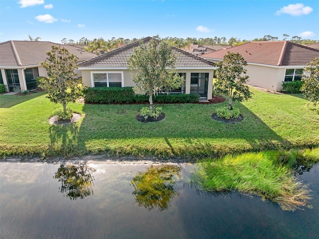 view of front of home featuring a front yard, a tiled roof, and stucco siding