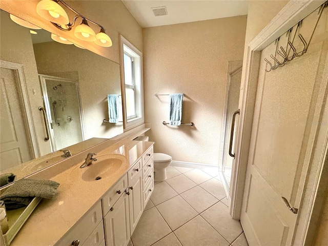 bathroom with tile patterned flooring, vanity, an enclosed shower, and toilet