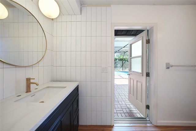 bathroom with hardwood / wood-style floors, vanity, and tile walls