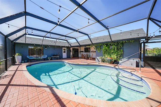 view of swimming pool with a patio area and a lanai