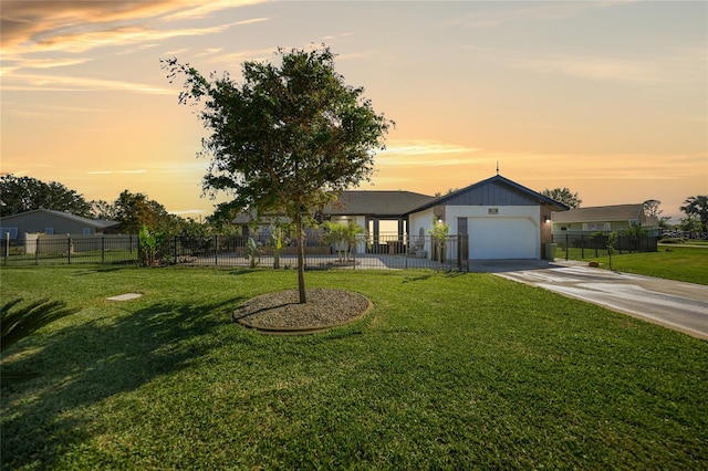 ranch-style home with a garage and a yard