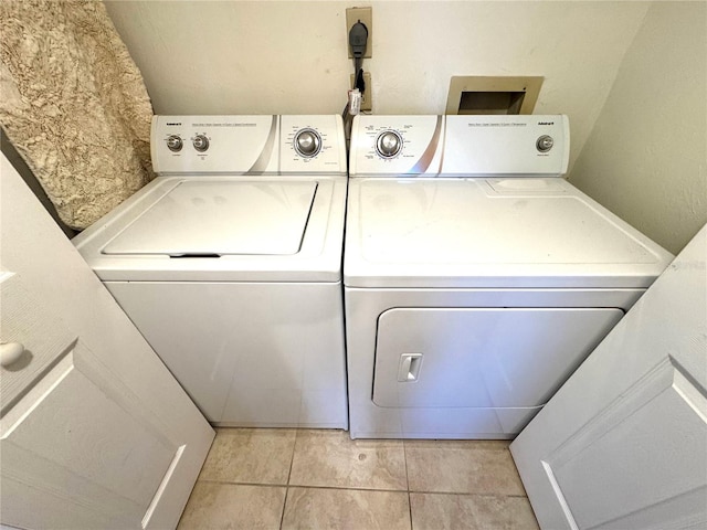 washroom with light tile patterned floors and washing machine and clothes dryer