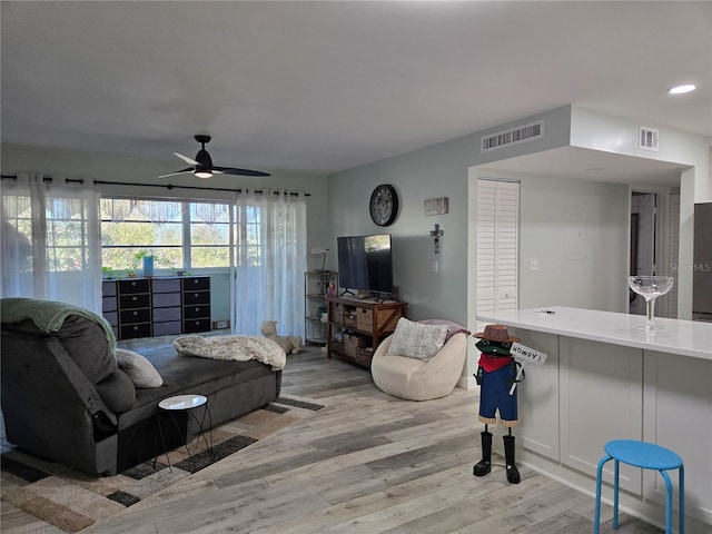 living room featuring light hardwood / wood-style flooring and ceiling fan