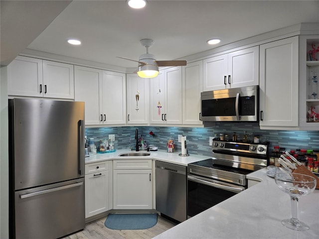 kitchen featuring appliances with stainless steel finishes, backsplash, white cabinetry, and sink