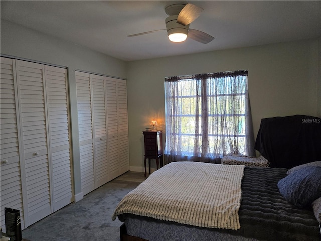 carpeted bedroom featuring ceiling fan and two closets