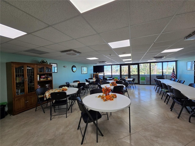 tiled dining area featuring a paneled ceiling