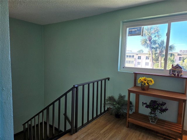 stairway featuring hardwood / wood-style flooring and a textured ceiling