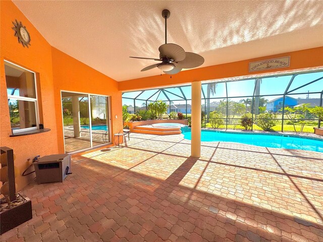 view of swimming pool featuring a patio area, an in ground hot tub, ceiling fan, and glass enclosure