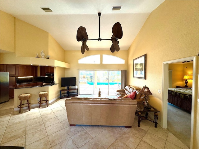 living room featuring ceiling fan, light tile patterned flooring, and lofted ceiling