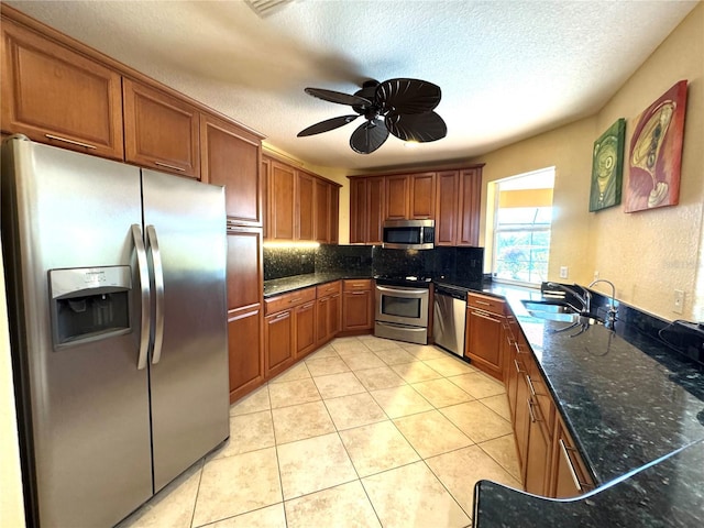 kitchen featuring ceiling fan, sink, backsplash, light tile patterned floors, and appliances with stainless steel finishes