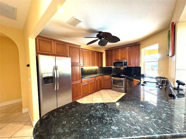 kitchen with backsplash, a textured ceiling, stainless steel appliances, ceiling fan, and sink