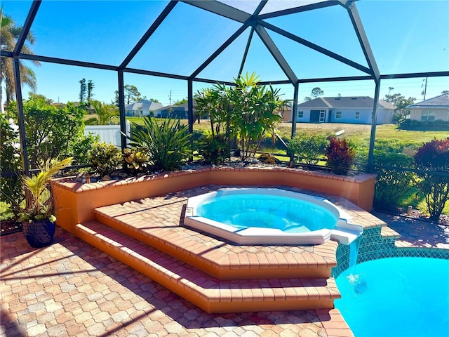 view of swimming pool with glass enclosure, an in ground hot tub, and a patio