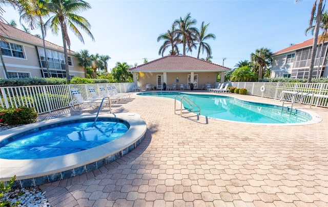 view of pool with a patio and a hot tub