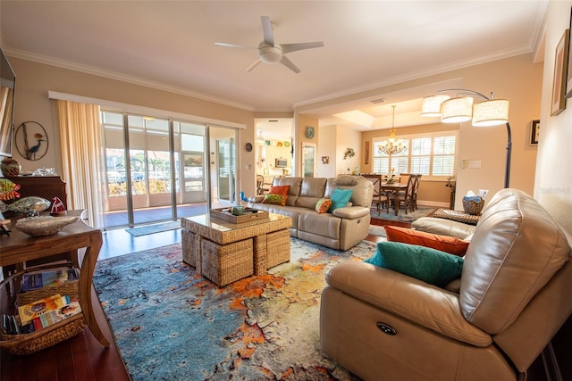 living room with hardwood / wood-style floors, ceiling fan with notable chandelier, and crown molding