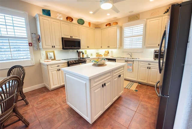 kitchen featuring a wealth of natural light, white cabinetry, and appliances with stainless steel finishes