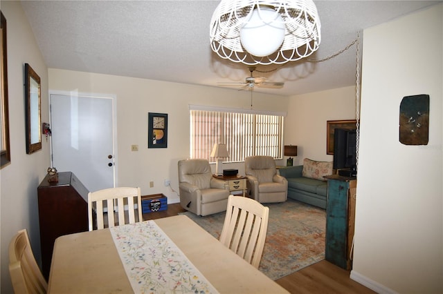 dining room with ceiling fan, wood-type flooring, and a textured ceiling