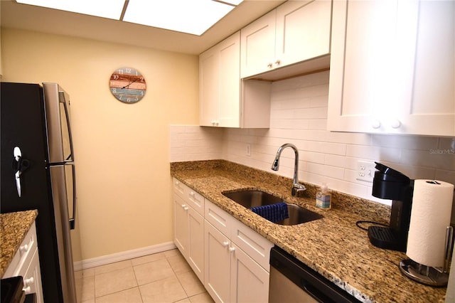 kitchen featuring decorative backsplash, appliances with stainless steel finishes, light stone counters, sink, and white cabinetry