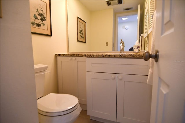 bathroom with tile patterned flooring, vanity, and toilet