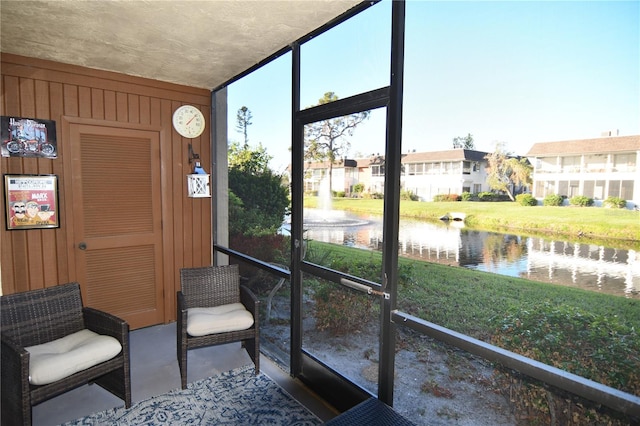 sunroom / solarium featuring a water view