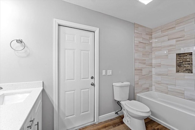 full bathroom with hardwood / wood-style flooring, vanity, toilet, and tiled shower / bath combo