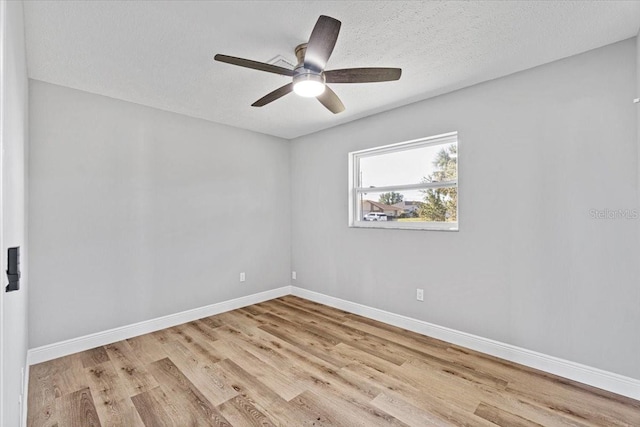 empty room featuring ceiling fan, light hardwood / wood-style flooring, and a textured ceiling