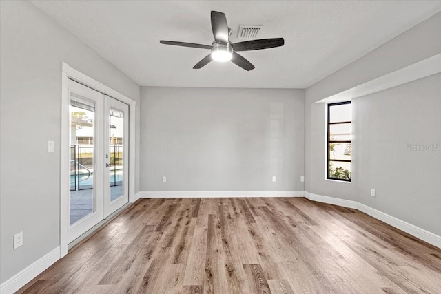 spare room featuring ceiling fan, light wood-type flooring, and french doors