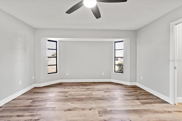 spare room with ceiling fan, light hardwood / wood-style floors, and a wealth of natural light