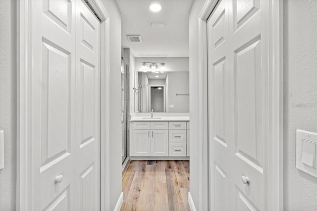 bathroom featuring vanity, an enclosed shower, and hardwood / wood-style flooring