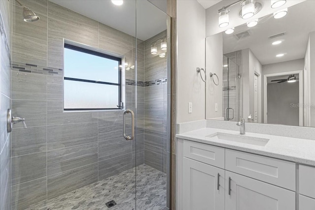 bathroom with ceiling fan, vanity, and walk in shower