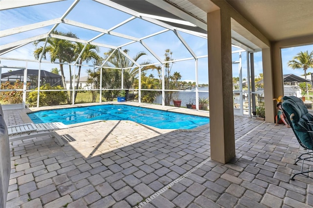 view of pool with a patio, a water view, and a lanai