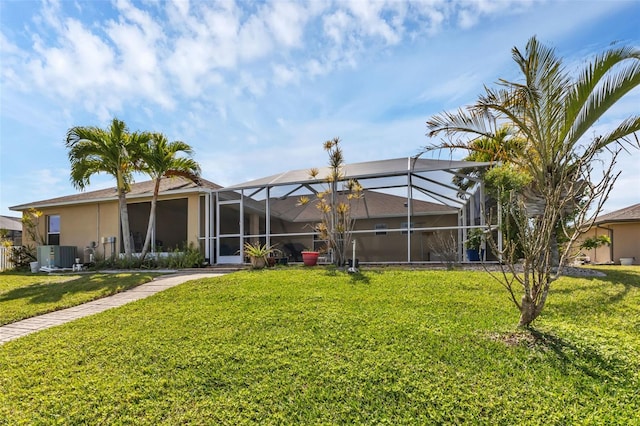 back of property with a lawn, glass enclosure, and central AC