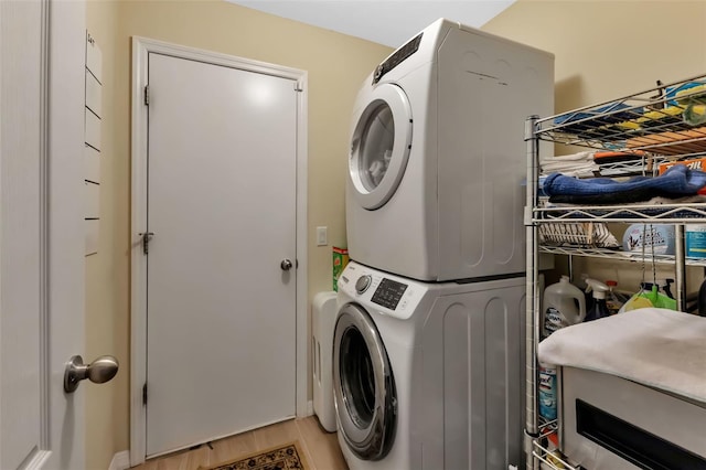 washroom with stacked washer and dryer and hardwood / wood-style flooring