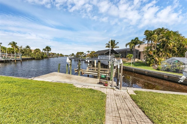 view of dock featuring a lawn and a water view