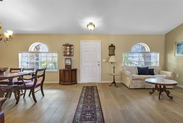 living room featuring an inviting chandelier and light wood-type flooring