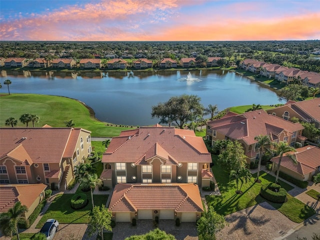 aerial view at dusk featuring a water view