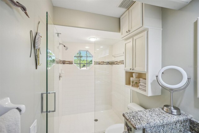 bathroom with a shower with door and toilet