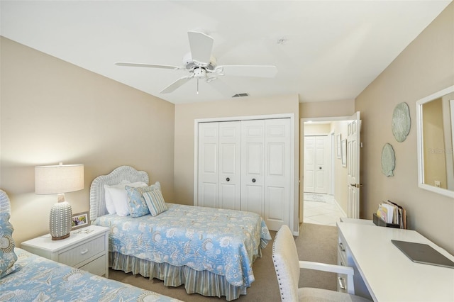 carpeted bedroom with ceiling fan and a closet