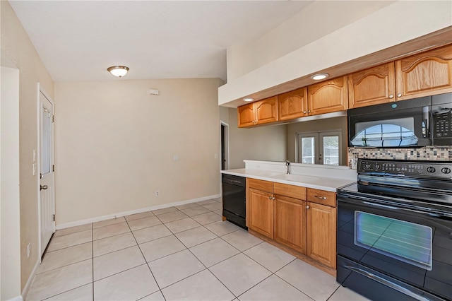 kitchen featuring french doors, sink, vaulted ceiling, light tile patterned floors, and black appliances