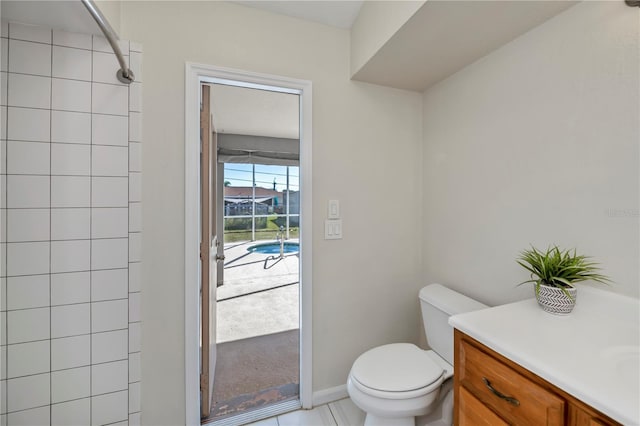 bathroom with tile patterned flooring, vanity, toilet, and tiled shower