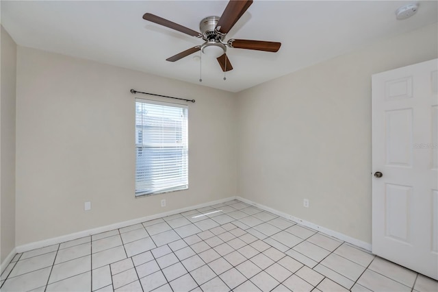 tiled spare room featuring ceiling fan