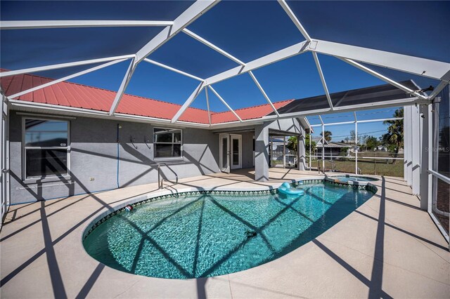 view of swimming pool featuring glass enclosure and a patio area