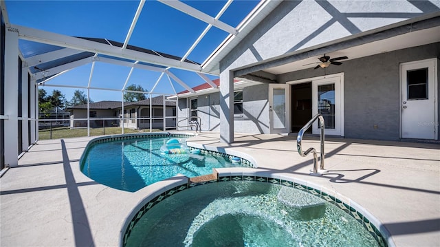 view of pool with a lanai, ceiling fan, a patio, and an in ground hot tub